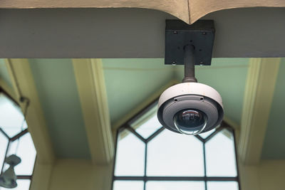 Low angle view of cctv camera hanging on ceiling 