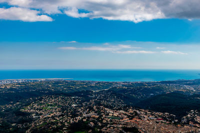 Aerial view of townscape by sea against sky