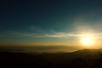 Scenic view of silhouette mountains against sky at sunset