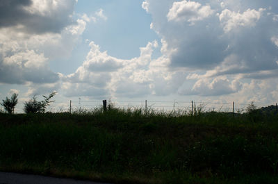 Scenic view of field against cloudy sky