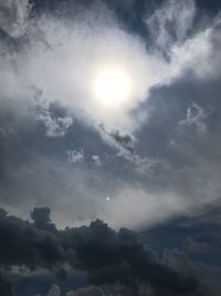 Low angle view of bright sun in sky