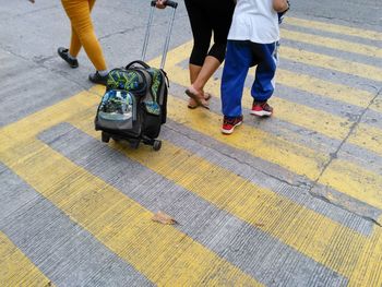 Low section of people standing on zebra crossing