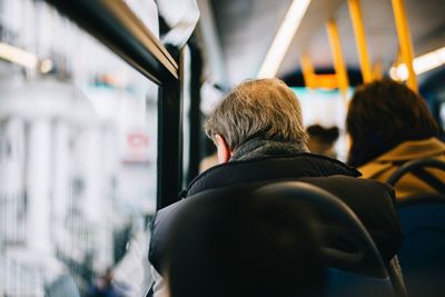 Full length rear view of man traveling in train