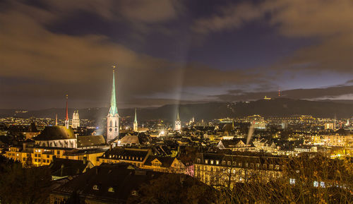 Illuminated buildings in city against sky