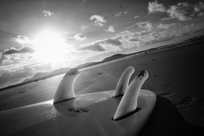 Airplane on beach against sky during sunset