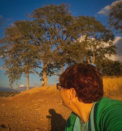 Rear view of woman looking at trees against sky