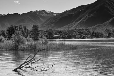 Scenic view of lake by mountains against sky