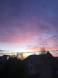 Low angle view of silhouette buildings against sky at sunset