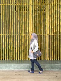 Full length of woman standing by railing