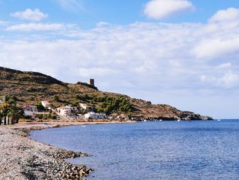 Scenic view of sea by buildings against sky