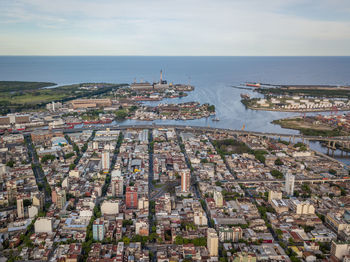 High angle view of town by sea against sky