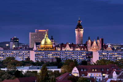 Illuminated buildings in city against sky at night