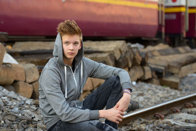 Portrait of young man standing on railroad track