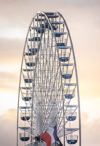 Low angle view of ferris wheel against cloudy sky