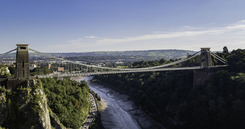 Bridge over river in city against sky