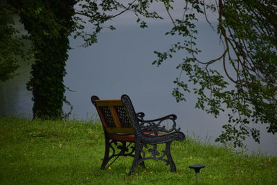 Empty chairs and table by lake