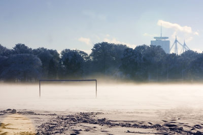 Playing field and trees against sky