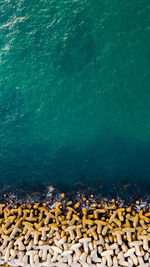 Aerial drone view over the sea and the breakwater at a sunny summer day