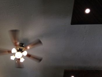 Low angle view of illuminated lamp hanging on ceiling