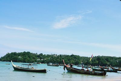 Longtail boat in sea against sky