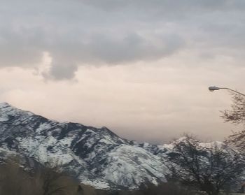 Low angle view of snowcapped mountains against sky