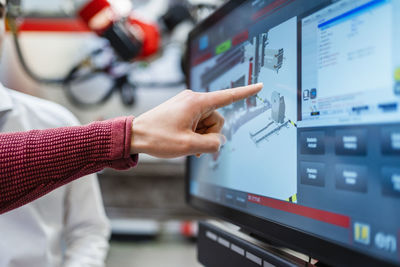 Hand of engineer pointing at computer screen at industry