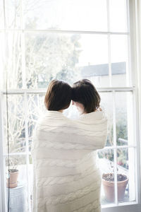 Couple wrapped in blanket looking