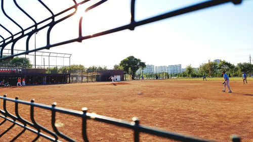 Group of people on field against fence