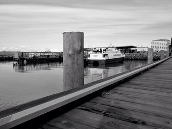 View of pier leading to sea against cloudy sky