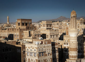 Buildings in city against clear sky