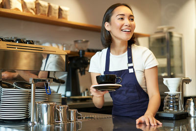 Portrait of young woman preparing food at home