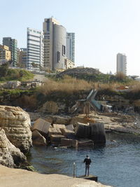 Buildings by sea against clear sky