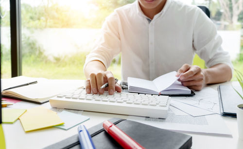 Midsection of man working on table
