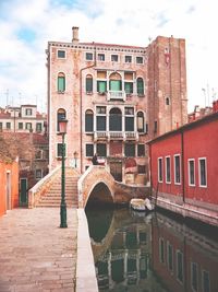 Arch bridge over canal against buildings in city