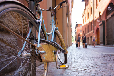 Bicycle parked on street amidst buildings