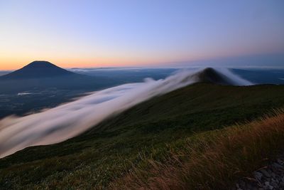 Scenic view of land against sky during sunset