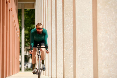 Side view of man riding bicycle on street