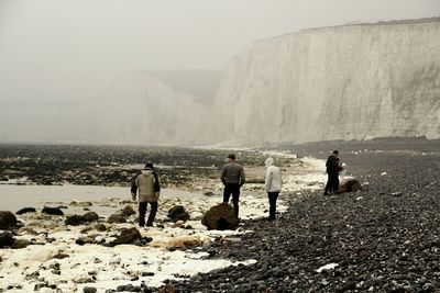 Rear view of people on sea during foggy weather