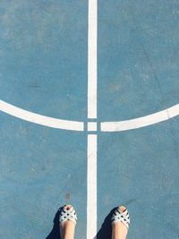 Low section of woman standing at basketball court