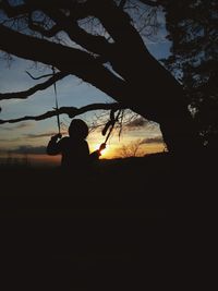 Silhouette trees against sky at sunset