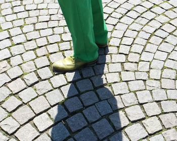 Low section of man standing on cobbled street