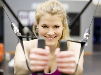 Portrait of young woman exercising in gym