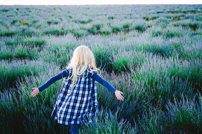 Woman amidst lavender plants on field