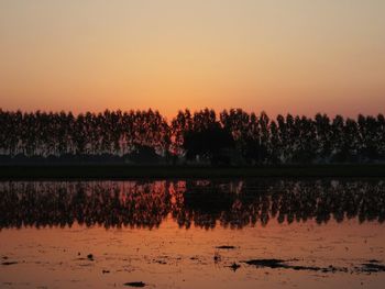 Scenic view of lake against orange sky
