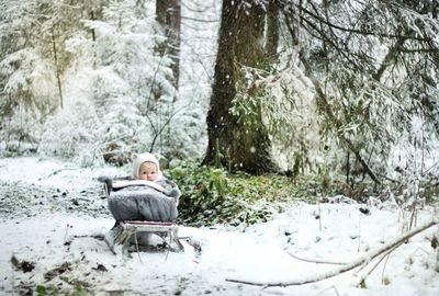 Man sitting on snow covered land