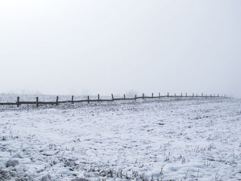 Scenic view of snow covered field against clear sky