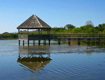 House by lake against sky