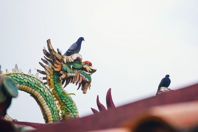 Low angle view of bird sculpture against clear sky