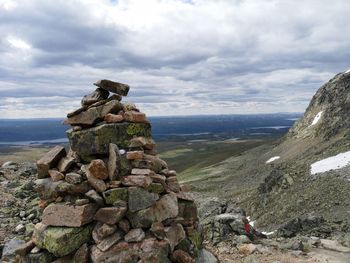 Stack of rocks on landscape against sky