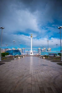 Street lights on footpath against blue sky